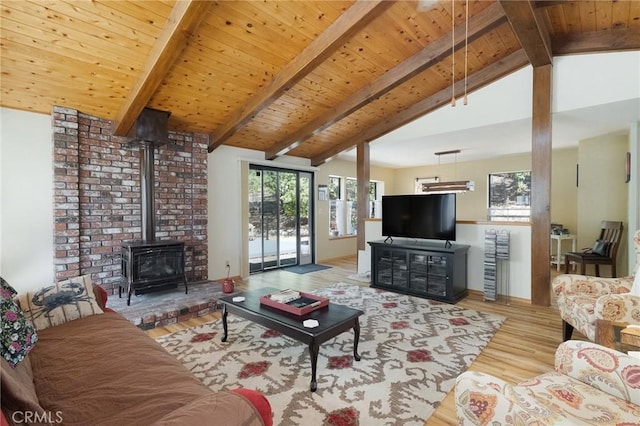 living room featuring vaulted ceiling with beams, wood ceiling, light wood-type flooring, and a wood stove