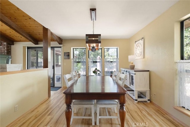 dining area featuring beam ceiling, plenty of natural light, and light wood-type flooring