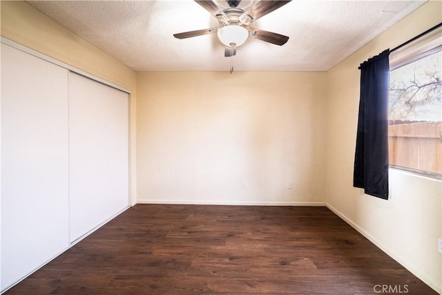 unfurnished bedroom with dark hardwood / wood-style flooring, ceiling fan, a closet, and a textured ceiling