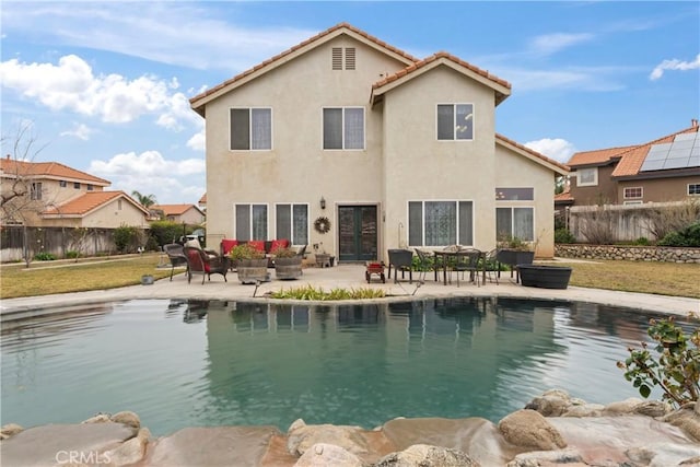 back of house with a fenced in pool and a patio area