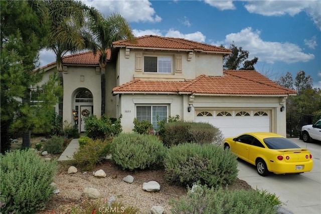 mediterranean / spanish home with a garage