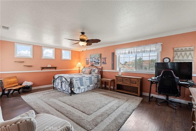 bedroom featuring ceiling fan, ornamental molding, dark hardwood / wood-style floors, and a textured ceiling