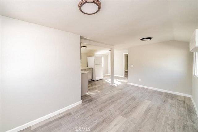 unfurnished room featuring vaulted ceiling and light hardwood / wood-style floors