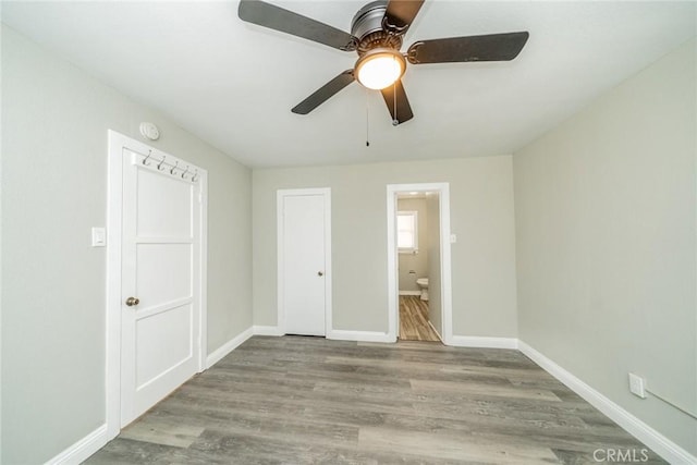 unfurnished bedroom featuring ensuite bath, light hardwood / wood-style flooring, and ceiling fan