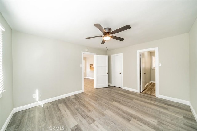 unfurnished bedroom featuring ensuite bathroom, ceiling fan, and light hardwood / wood-style flooring