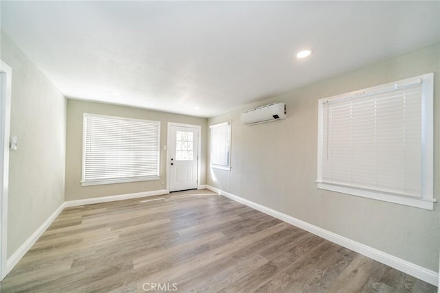 entryway featuring light wood-type flooring and an AC wall unit