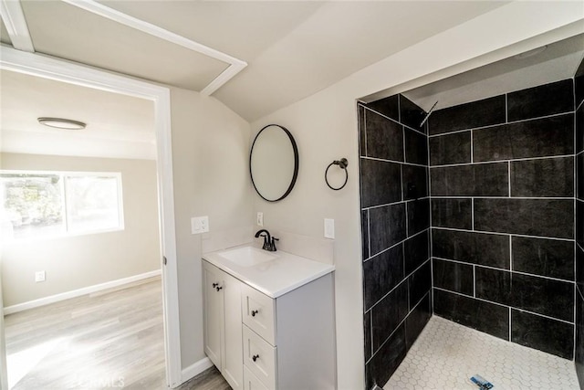 bathroom with vanity, hardwood / wood-style flooring, and tiled shower