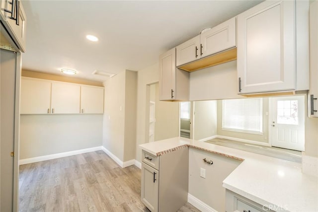 kitchen featuring a wealth of natural light, light hardwood / wood-style flooring, and white cabinets