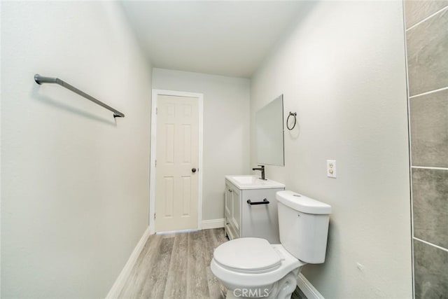 bathroom featuring wood-type flooring, toilet, and vanity