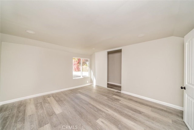 unfurnished room with vaulted ceiling and light hardwood / wood-style floors