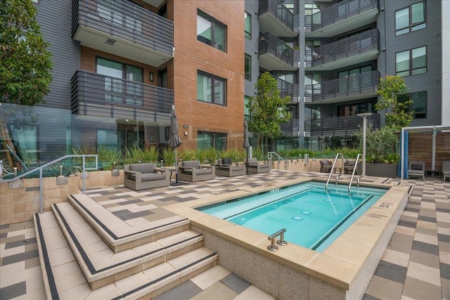 view of pool featuring a community hot tub and a patio area