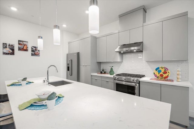 kitchen with sink, gray cabinets, hanging light fixtures, and high quality appliances