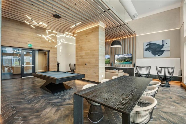 playroom featuring pool table, dark parquet flooring, wooden walls, and a high ceiling