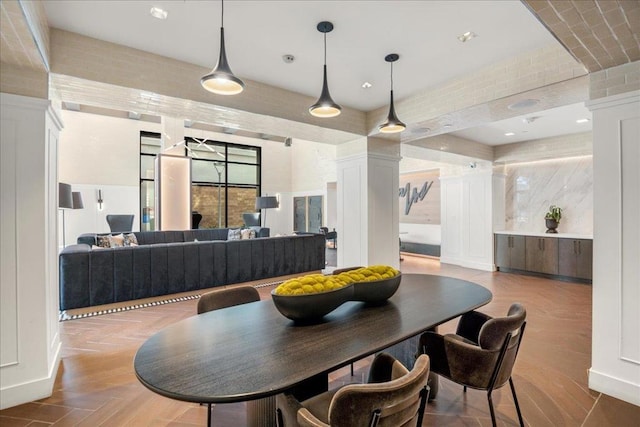 dining room featuring light hardwood / wood-style floors and decorative columns