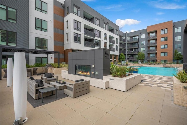 view of pool with a multi sided fireplace and a patio area