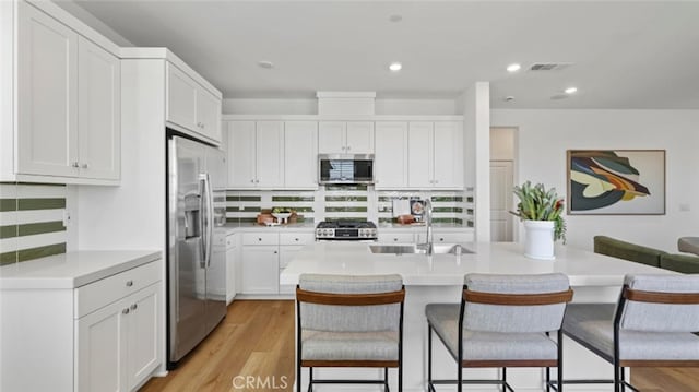 kitchen featuring white cabinetry, sink, a breakfast bar area, and stainless steel appliances