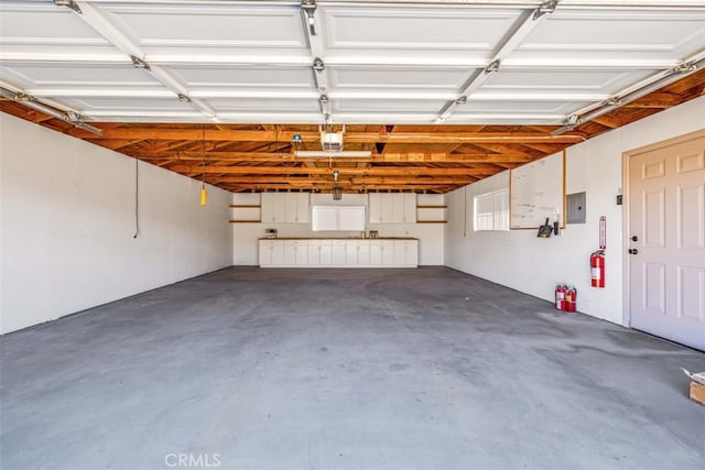 garage with a garage door opener and electric panel