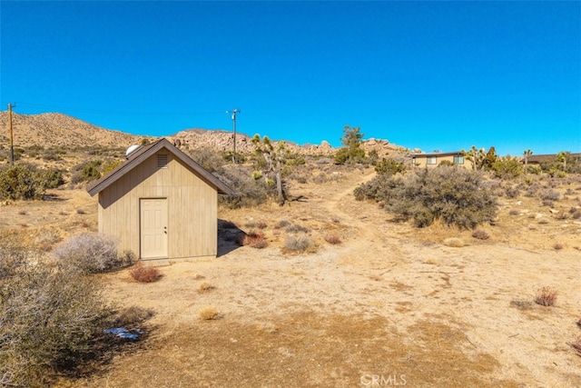 view of yard featuring a mountain view and a shed