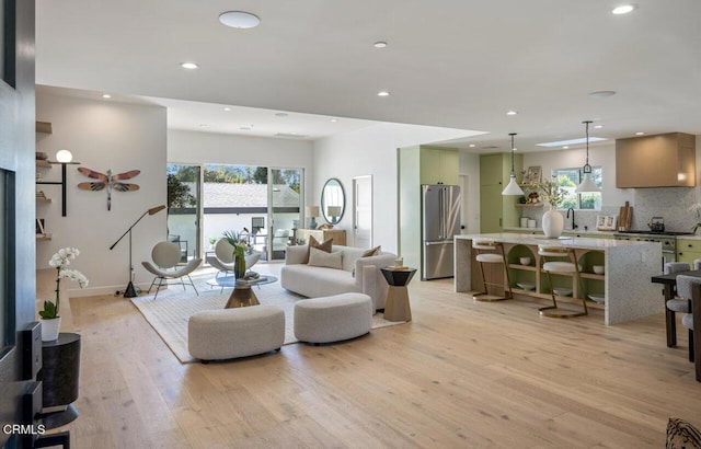 living room featuring sink, a wealth of natural light, and light hardwood / wood-style flooring