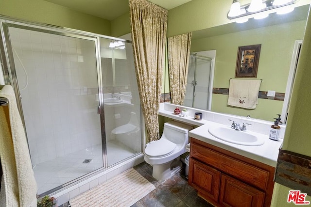 bathroom with vanity, toilet, and a shower with door