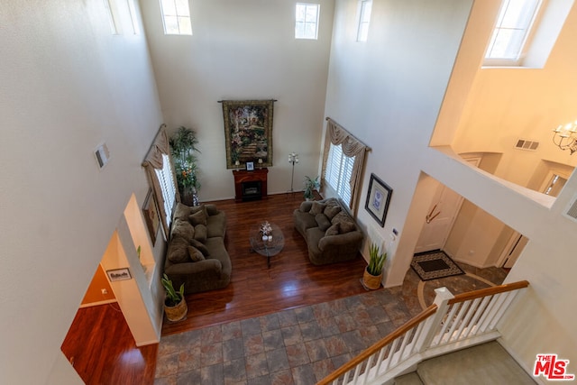 living room featuring dark hardwood / wood-style flooring and a towering ceiling