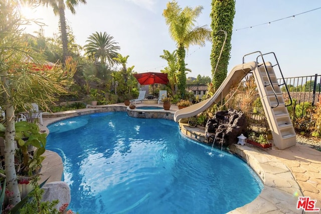 view of pool featuring an in ground hot tub and a water slide