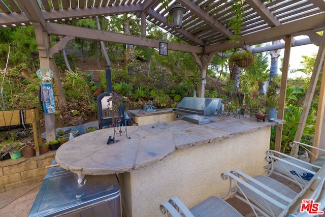 view of patio / terrace with a bar, an outdoor kitchen, a pergola, and area for grilling