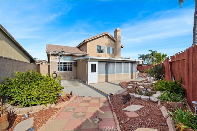 rear view of house with a patio area and a sunroom