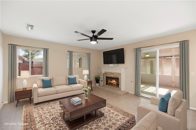 living room with ceiling fan, light tile patterned floors, and a fireplace