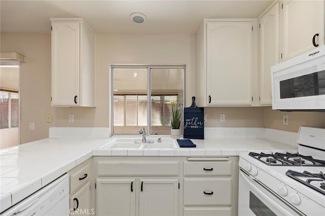 kitchen featuring white cabinetry, white appliances, and tile countertops