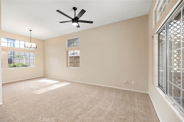 unfurnished room featuring carpet flooring and ceiling fan with notable chandelier