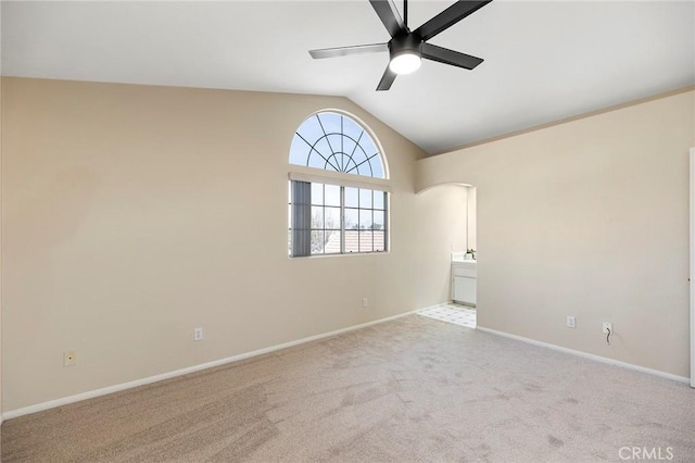 empty room featuring ceiling fan, light colored carpet, and lofted ceiling