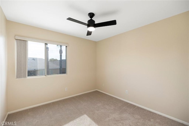 spare room featuring ceiling fan and light colored carpet