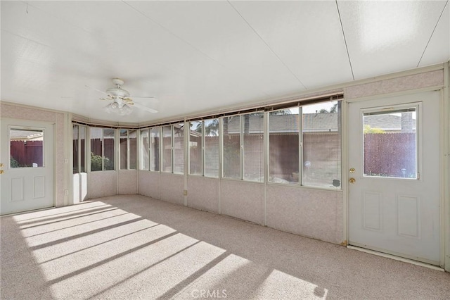 unfurnished sunroom featuring ceiling fan