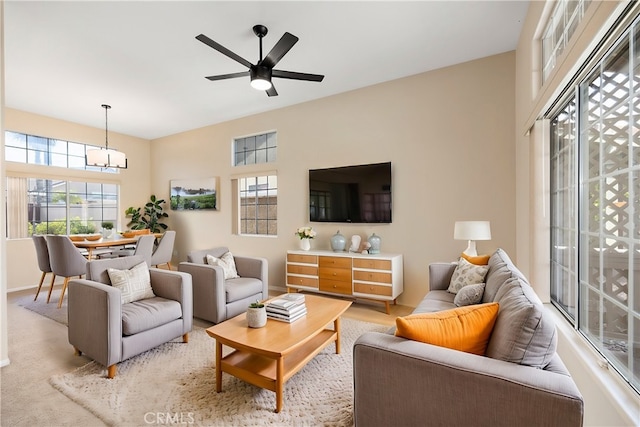 living room with ceiling fan with notable chandelier