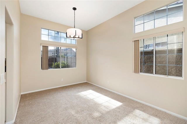 empty room featuring a chandelier and carpet