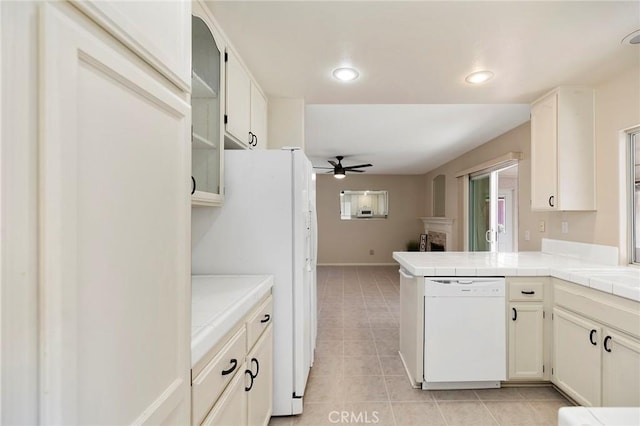 kitchen featuring light tile patterned floors, tile counters, ceiling fan, kitchen peninsula, and white appliances