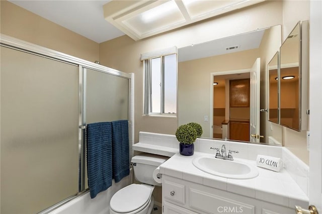 full bathroom featuring shower / bath combination with glass door, vanity, and toilet