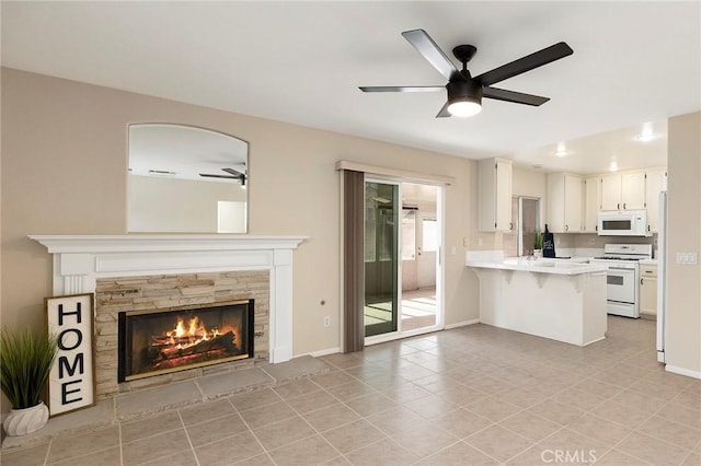 unfurnished living room with light tile patterned floors, a fireplace, and ceiling fan