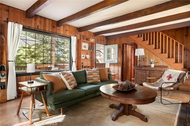 living room featuring beamed ceiling, wood-type flooring, and wood walls