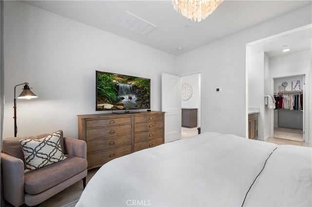 bedroom featuring a walk in closet and a chandelier