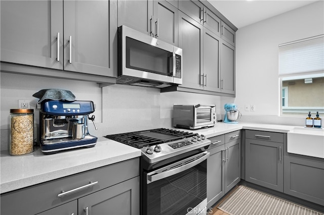 kitchen featuring sink, gray cabinets, and appliances with stainless steel finishes