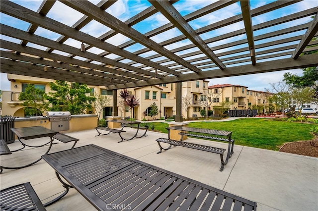 view of patio with area for grilling, a pergola, and an outdoor kitchen