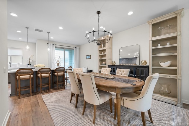 dining area with hardwood / wood-style floors and a chandelier