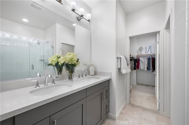 bathroom featuring tile patterned flooring, vanity, and a shower with shower door