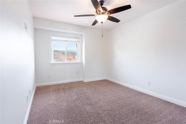 spare room with ceiling fan and carpet