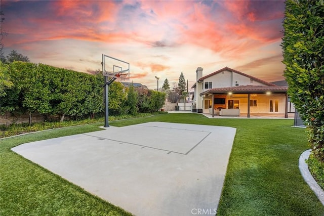 view of sport court featuring a yard