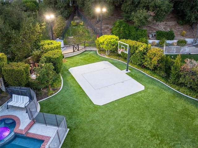 view of sport court with a lawn