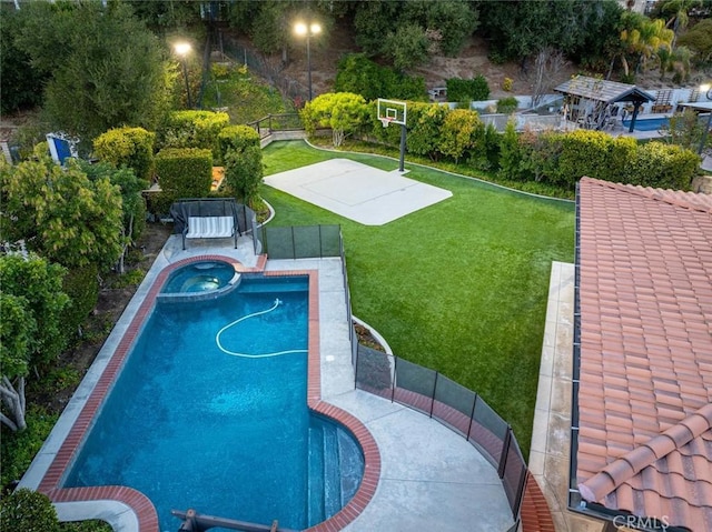 view of pool featuring basketball court, a lawn, and an in ground hot tub