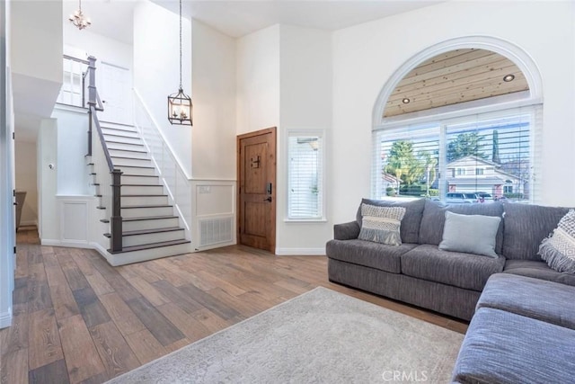 living room with hardwood / wood-style floors, a high ceiling, and a notable chandelier